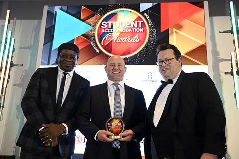 Joss Muirie of Abodus presents the award to Huw Forest of JLL with Stephen K Amos