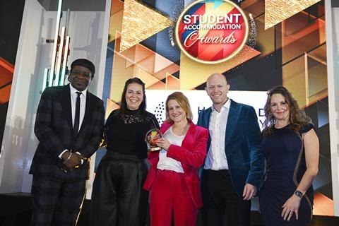 Astrid Stanley of Howard Kennedy gives the Social Impact trophy to Laura Dalgleish, Alex Moon & James Mortimer of iQ